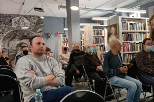 miejsce- biblioteka publiczna. Pomiędzy regałami z książkami siedzą na krzesłach podopieczni ŚDS, są zasłuchani w wykład