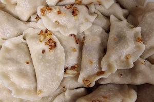 na zdjęciu pokazane są w przybliżeniu pierogi, okraszone przysmażoną cebulką