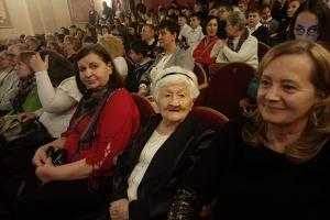 na zdjęciu widzimy zapełnioną salę teatralną widzami. Na pierwszym planie trzy kobiety uśmiechają się do zdjęcia.
