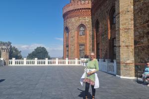 W tle widać pałacową wieżę, na pierwszym planie podopieczna ŚDS pozuje do zdjęć