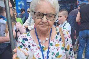 Seniorka prezentuje sowę z drewna zrobioną na warsztatach
